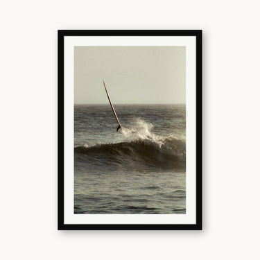 Black wood frame fine art print of Ghost Rider by Devon Cardamone, San Onofre, CA — a longboard launches skyward at San Onofre — the cobblestone break where Southern California surf culture took root in the 1930s.