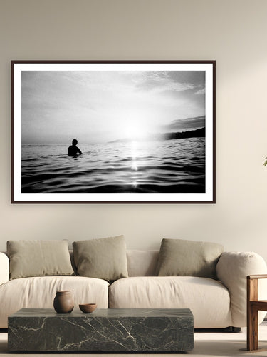 Lonely Surfer by Devon Cardamone from La Bocana, El Salvador - framed black frame fine art photography displayed in a modern living room setting