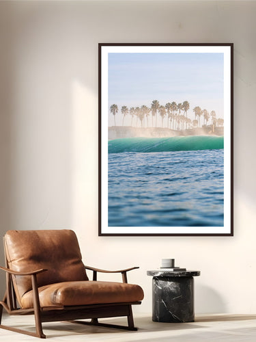 Black wood frame fine art print of Palm Trees and Sea Spray by Luis Ortega, San Diego, California, displayed on a reading nook wall — a clean shore break off a San Diego beach, palms catching the salt spray.