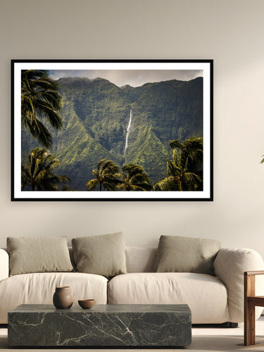 Black wood frame fine art print of Mountain Pulse by The Pickled Image, Hanalei, Kaua'i, displayed on a modern living room wall — nāmolokama — the mountain behind Hanalei whose waterfalls appear to flow straight out of the clouds.