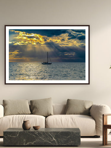 Black wood frame fine art print of Hawaiian Sunset by Tom Ingram, Maui, Hawai'i, displayed on a modern living room wall — sunset on the ʻAuʻau Channel between Maui and Lānaʻi — 'ʻauʻau' is Hawaiian for 'to take a bath,' a name earned by the channel's bathtub calm.