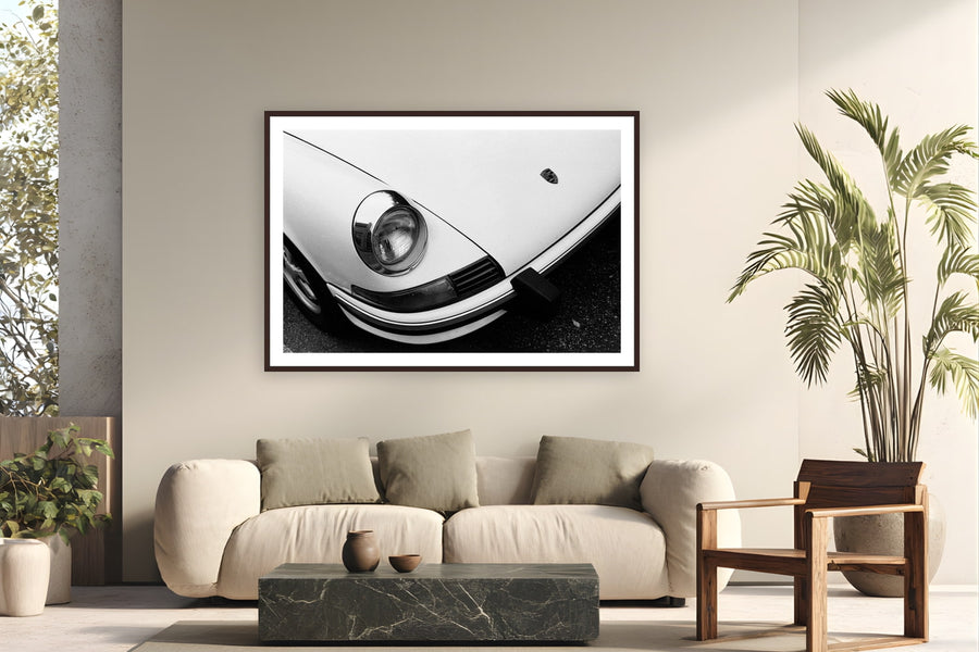 Black wood frame fine art print of Porsche Curves by Adam Sherrett, Venice Beach, California, displayed on a modern living room wall — a classic air-cooled 911 on a Venice Beach street — even parked, it looks fast.