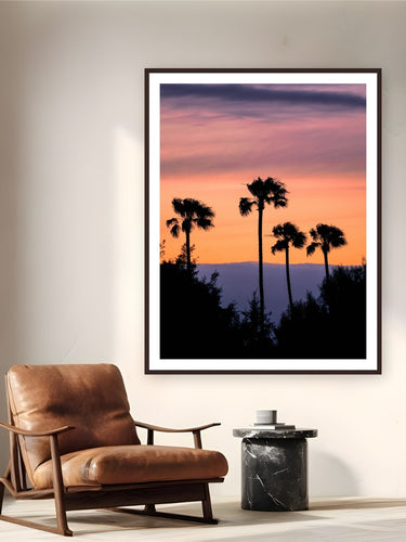 Four Palms by Alex Wood from Santa Monica, California - framed black frame fine art photography displayed in a reading nook setting