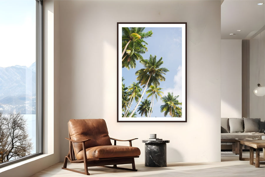 Black wood frame fine art print of Reaching by Ben Gamlin, Mentawai Islands, Sumatra, Indonesia, displayed on a reading nook wall — looking up through the palms of the Mentawai Islands, off Sumatra's west coast.