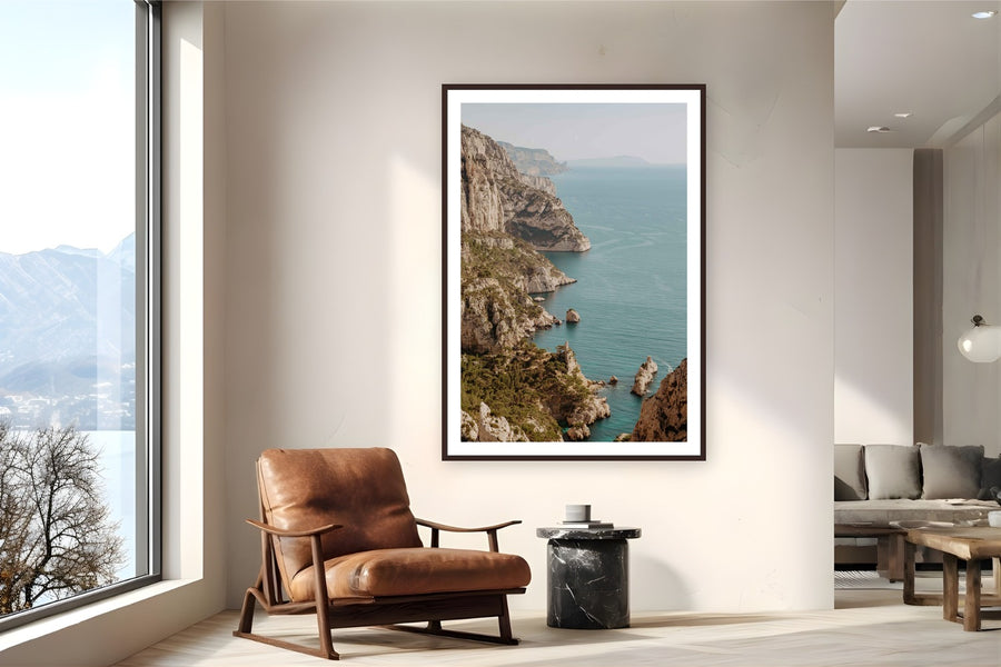 Les Calanques by Bree Banning from Marseille, France - framed black frame fine art photography displayed in a reading nook setting