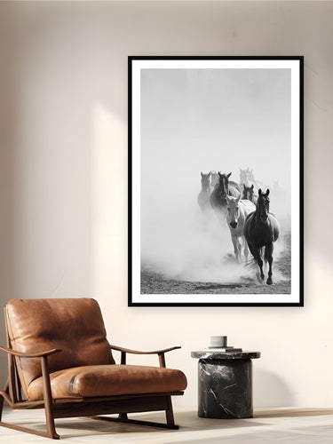 Black wood frame fine art print of Wrangling the Herd by Brooklyn Phillips, Moran, Wyoming, displayed on a reading nook wall — every morning at Triangle X, the herd comes in from open pasture — pushed through the Teton valley dust before the day's first ride.