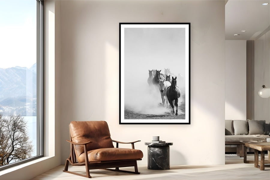 Black wood frame fine art print of Wrangling the Herd by Brooklyn Phillips, Moran, Wyoming, displayed on a reading nook wall — every morning at Triangle X, the herd comes in from open pasture — pushed through the Teton valley dust before the day's first ride.