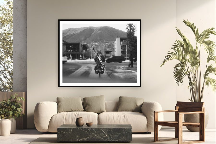 Black wood frame fine art print of Morning Commute by Devon Cardamone, Aspen, CO, displayed on a modern living room wall — downtown Aspen — where the mountain is close enough to bike to with your skis on your back.