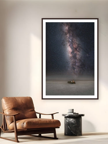Between Worlds by Max Dickson from Makgadikgadi Salt Pans, Botswana - framed black frame fine art photography displayed in a reading nook setting