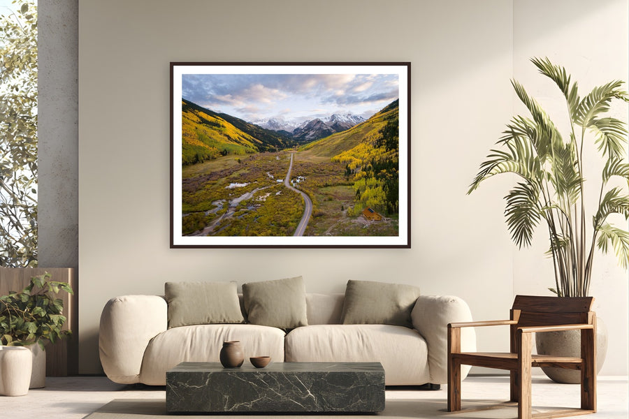 When Mountains Dream in Gold by Sam Ferguson from Ashcroft, Colorado - framed black frame fine art photography displayed in a modern living room setting