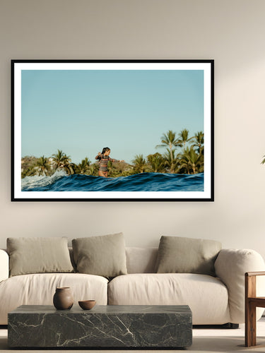Black wood frame fine art print of Cross Step by Sarah Swan, Mexico, displayed on a modern living room wall — kelis cross-stepping on a longboard at the 2022 Mexi Log Fest — palm trees, warm water, and free surf before the competition.