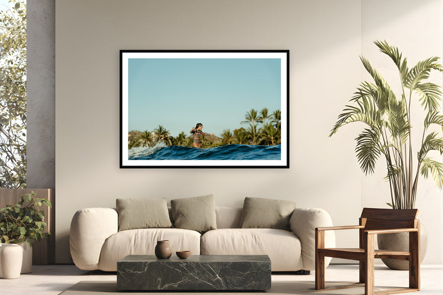Black wood frame fine art print of Cross Step by Sarah Swan, Mexico, displayed on a modern living room wall — kelis cross-stepping on a longboard at the 2022 Mexi Log Fest — palm trees, warm water, and free surf before the competition.